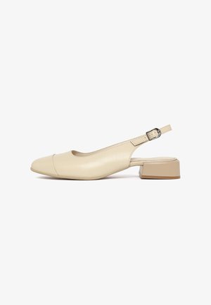 Beige leren slingback-schoen met een lage blokhak, een afgeronde neus en een verstelbare metalen gespsluiting.