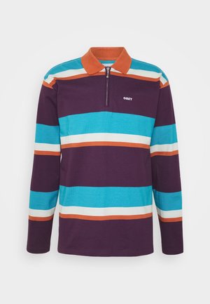 Long-sleeve polo shirt in purple, featuring horizontal stripes in teal, white, and orange. Includes a zip collar and white logo on chest.