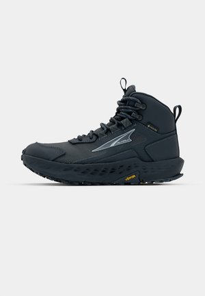 Keskmise kõrgusega hall matkasaapad, millel on võrgusilmast ülemine osa, vastupidav kummist talla, tekstureeritud aktsendid ja Vibram brändimine taldadel.