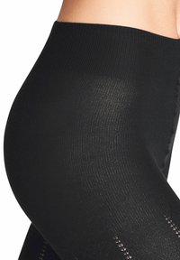 Schwarze Leggings mit einem gerippten Bund, die eine glatte Textur und dekorative, offene Strickmuster an den Unterschenkeln aufweisen.