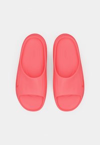 Ζευγάρι ροζ κοραλλί ανοιχτού τύπου πέδιλα με υφασμάτινες σόλες, τοποθετημένα δίπλα-δίπλα σε λευκό φόντο.