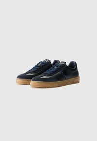 Sneaker blu navy realizzati in suede e pelle, con lacci rotondi, una suola in gomma testurizzata color gum e un logo discreto sul lato.