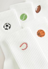 Chaussettes blanches côtelées, chacune brodée avec un ballon de sport différent : football, tennis, football américain, basket-ball et baseball.
