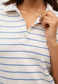 Polo in crema con strisce orizzontali azzurro chiaro, dotato di colletto, placket a due bottoni e tessuto morbido e testurizzato.