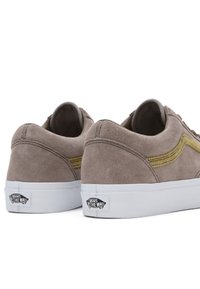 Sneakers in suede grigio con suola in gomma bianca e dettagli in cucitura gialla. Presentano un design classico e un logo Vans sul tallone.