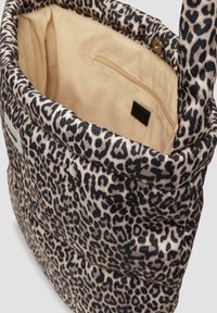 Tote tas met een buitenkant van luipaardprint stof, beige binnenvoering, een ritsvakje aan de binnenkant en een drukknoopsluiting aan de bovenrand.
