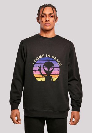 Black sweatshirt featuring graphic of an alien silhouette with a peace sign, set against a multicolored circle background with stripes.