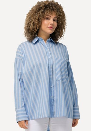 Camisa de rayas azul y blanca, de manga larga, con botones en la parte delantera, gran bolsillo en el pecho, corte relajado, textura de tela suave.