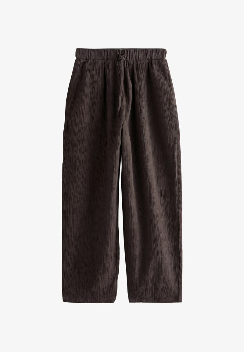 Pantalones marrones con textura, de corte holgado, con cintura elástica y cordón, con bolsillos laterales y piernas rectas.