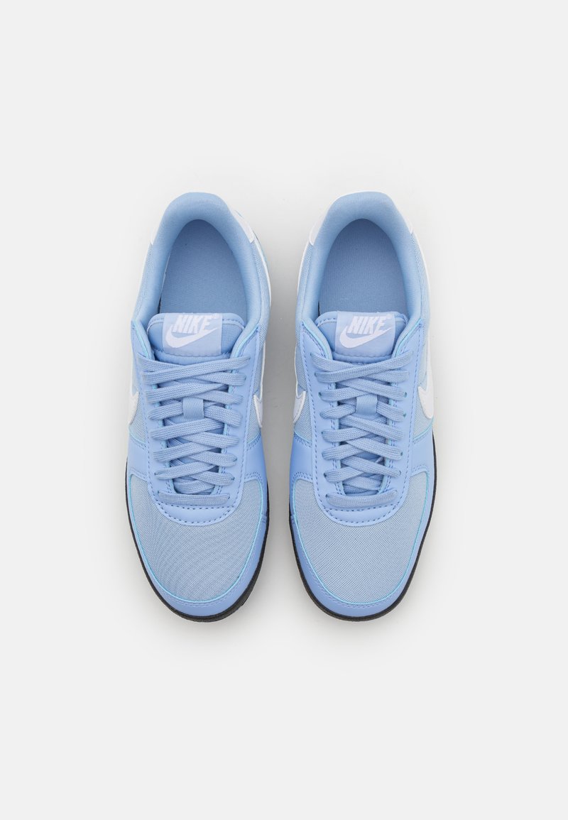 Jasnoniebieskie sneakersy mają siateczkową i syntetyczną cholewkę z białym logo, okrągłym czubkiem oraz sznurowanym zapięciem. Gumowa podeszwa zapewnia przyczepność.