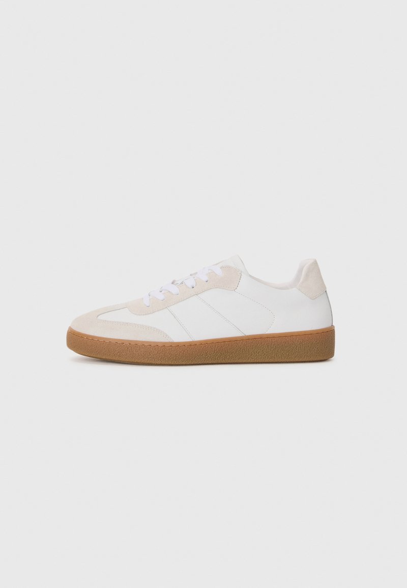 Sneaker bianco e beige con elementi in suede e pelle. Presenta una suola in gomma, un design con lacci e righe laterali minimaliste.