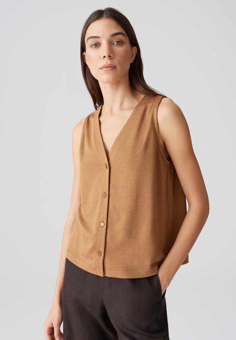 Top sans manches brun avec un décolleté en V profond et des boutons en bois sur le devant. Le matériau semble doux avec une texture lisse, présentant une coupe ample.