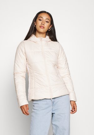 Giacca puffer di colore rosa chiaro con chiusura a zip frontale, cappuccio integrato e polsini elasticizzati. Presenta un logo discreto e una texture trapuntata.