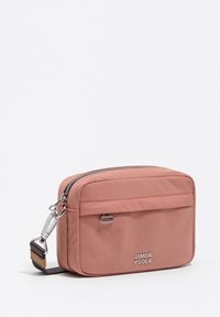 Różowa nylonowa torba na ramię o prostokątnym kształcie, z srebrnym zamkiem błyskawicznym, regulowanym paskiem i tłoczonym logo z przodu.