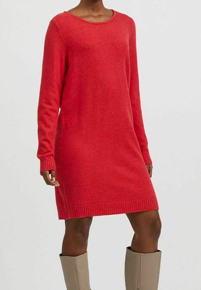 Robe en maille rouge avec un col rond, manches longues et poignets côtelés. Texture douce, coupe légèrement ample, longueur au-dessus des genoux.
