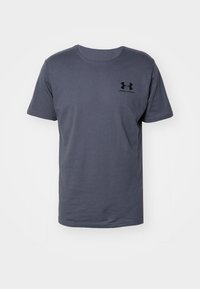 Camiseta gris de manga corta hecha de algodón, con un cuello redondo y un pequeño logo negro en el área del pecho izquierdo.