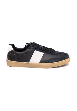 Czarne i granatowe sneakersy z białym paskiem, wykonane z zamszu i skóry, o okrągłym nosie, z czarnymi sznurówkami i podeszwą z gumy.