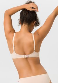 Hautfarbener BH mit glatter Textur, verstellbaren Trägern und Haken- und Ösenverschluss auf der Rückseite. Einfaches Design mit minimalen Akzenten.