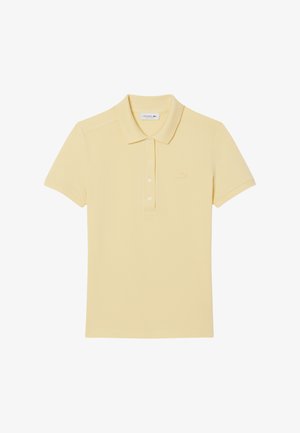 Polo en coton doux jaune pâle. Présente un col classique, une patte de boutonnage à trois boutons, des manches courtes et un logo brodé subtil sur la poitrine.