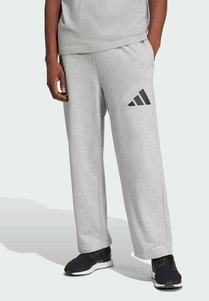 Lichtgrijze sweatpants met een relaxte pasvorm, met een zwart driehoekig logo op de linkerdij. De stof lijkt zacht, ideaal voor casual kleding.