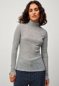 Hellgraues langärmliges Rollkragen-Shirt aus weichem, strukturiertem Stoff. Verfügt über ein figurbetontes Design mit schmalen Ärmeln und einem hohen Kragen.