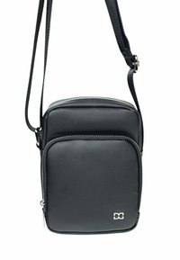 Sac bandoulière noir en matériau texturé, doté d'une fermeture éclair, d'une poche avant et d'une bandoulière. Détail du logo sur le devant.