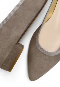 Bailarinas de ante gris con punta afilada y suela de goma. Presentan un ribete elástico texturizado gris a lo largo de la abertura. Diseño minimalista.