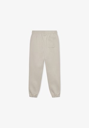 Jogging léger beige avec une taille élastique, des poignets fuselés et une poche arrière. Fait en tissu doux et lisse.