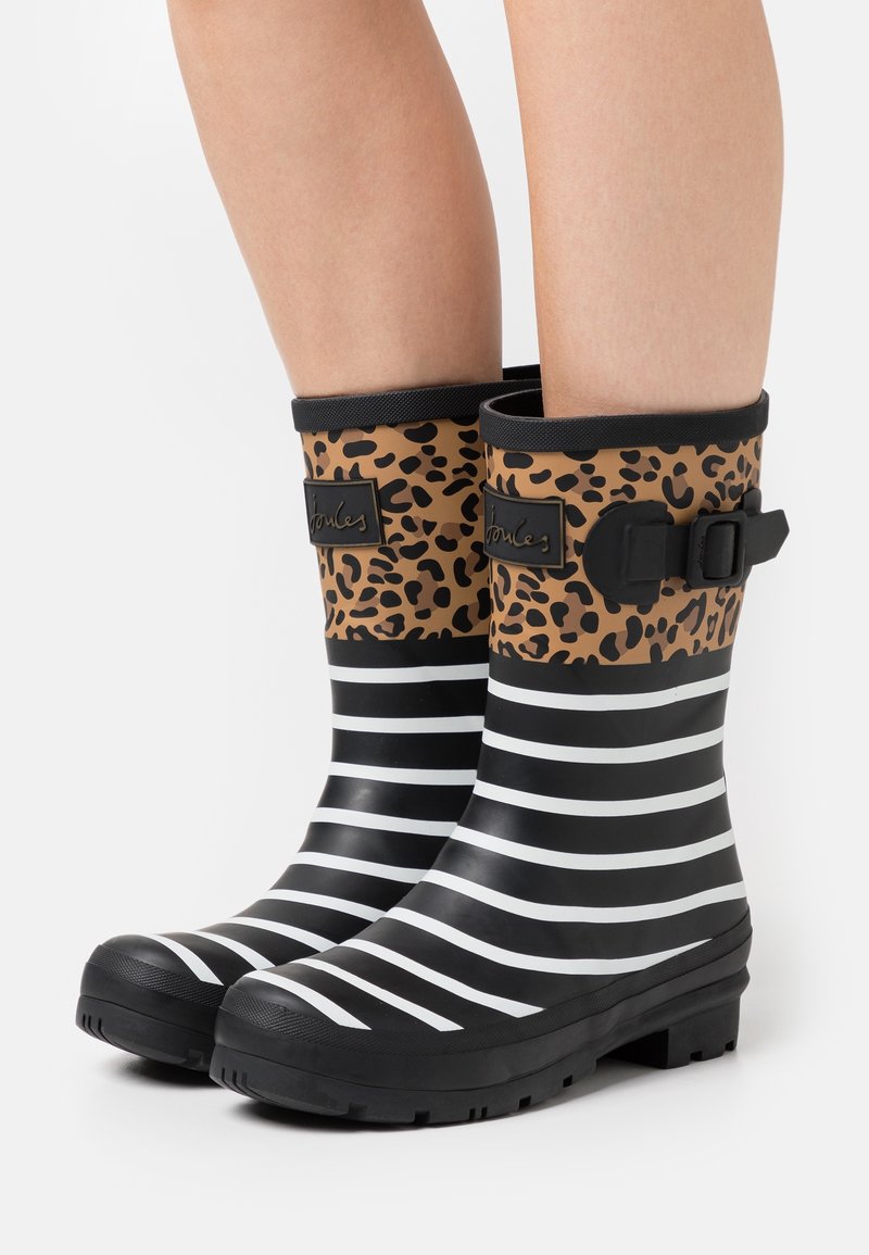 Bottes de pluie en caoutchouc à rayures noir et blanc avec un dessus en imprimé léopard et un détail de boucle, dotées d'une semelle texturée pour une bonne adhérence et durabilité.