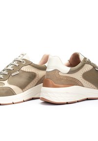 Baskets beiges et olive avec des panneaux en daim et en cuir lisse, bout rond, épaisse semelle intermédiaire blanche et lacets légers. Présente des coutures contrastées.