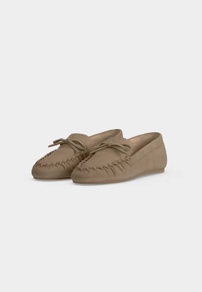 Paire de mocassins beiges en daim style slip-on avec couture à l'avant et nœud noué sur chaque dessus.