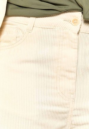 Kremne kordurojske hlače z navpično rebrastim vzorcem, ki imajo stranske žepke, gumbasto zapiranje in kontrastno šivanje ob šivih.