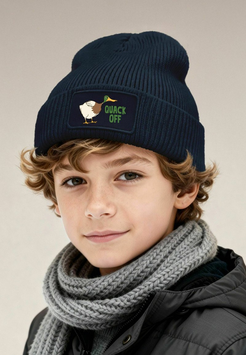 Navy knitted beanie with a rectangular patch featuring a duck illustration and the text "QUACK OFF" in green. Textured, warm fabric.