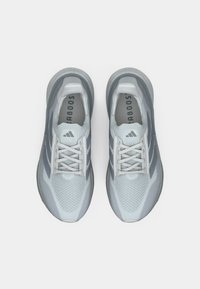 Αθλητικά παπούτσια ανοιχτού γαλάζιου χρώματος από διαπνέον πλέγμα με γκρι λεπτομέρειες, διαθέτουν επίπεδα κορδόνια και υφασμένες σόλες. Το λογότυπο της Adidas είναι ορατό.