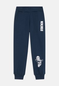 Marineblaue Sweatpants mit geripptem Bund, seitlichen Taschen, schmal zulaufenden Bündchen und einem weißen "Ninjago"-Logo mit einem Lego-Charaktergrafik.