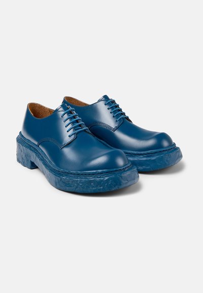 Blue leather lace-up shoes with a textured blue rubber sole and smooth upper. Rounded toe and subtle stitching details on the sides.
