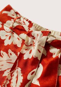 Rode stoffen met bloemen in crèmekleur, met plooien en een elastische tailleband voor een verstelbare pasvorm. Zachte, getextureerde stof.