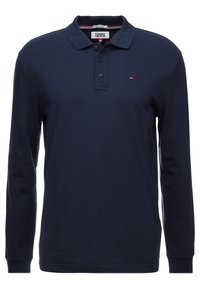 Mörkblå långärmad pikétröja med krage och treknappsslutning, liten Tommy Jeans-logotyp på vänster bröst.