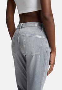 Lichtgrijze denim jeans met een gemiddelde taillehoogte, een vijf-pocket ontwerp en subtiele stiksels op de achterzakken.