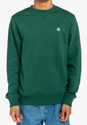 Sweatshirt vert en tissu doux et texturé. Doté d'un col rond et de poignets côtelés. Petit logo décoratif sur la poitrine.