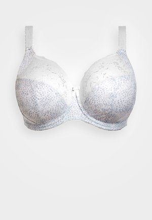 Rintaan tuki, vaalean valkoisena, jossa on pitsikoristeita ja pilkullinen kuvio. Varustettu säädettävillä olkaimilla ja tukevalla etulukoilla.