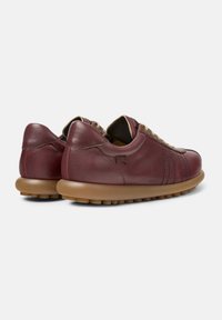 Maroon leather sneakers with a rounded light brown sole, featuring a textured design and laces, viewed from the back.