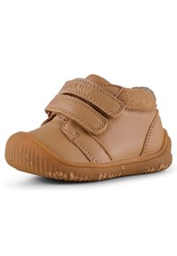 Scarpe in pelle per bambini piccoli di colore testa di moro con una finitura morbida e texture. Presentano due cinturini in velcro e una suola in gomma flessibile con un motivo scanalato.