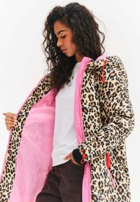 Pufová bunda s leopardím potiskem a růžovou podšívkou, nastavitelnou kapucí a elastickými manžetami; obsahuje zip a šňůrkovou přezku.