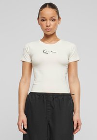 Kra short-sleeve krēma t-krekls ar melnu logo druku uz priekšpuses, ar pieguļošu dizainu un gludu auduma tekstūru.