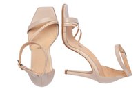 Sandalias de tacón alto beige con punteras cuadradas, una delgada correa en el tobillo y tiras cruzadas. Parte superior de piel suave y tacón de aspecto madera.