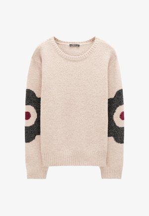 Beżowy sweter dzianinowy z prążkowanymi mankietami i krawędzią, zdobiony dużymi czarno-beżowymi wzorami kwiatowymi z czerwonymi środkami na obu rękawach.