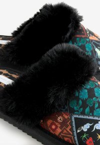 Black faux fur slippers featuring a patterned textile upper with floral and geometric designs, and a textured black sole.