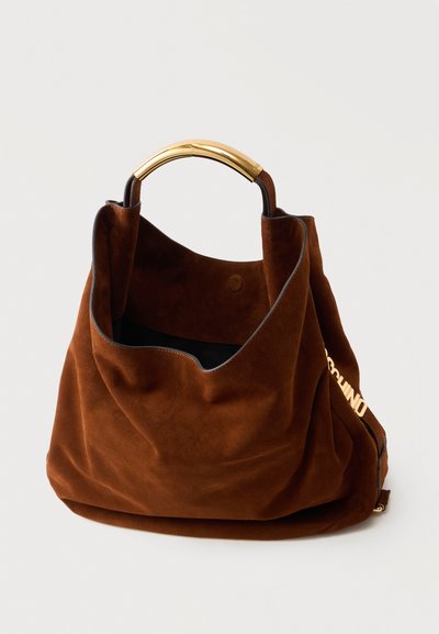 Καφέ καστόρινη τσάντα με χαλαρή μορφή και χερούλι από χρυσό μέταλλο, με μερική χρυσή επιγραφή στο πλαϊνό λουρί.