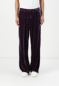 Sammet, vida lila byxor med elastisk midja och dragsko, med en mjuk textur och en lätt glansig yta.